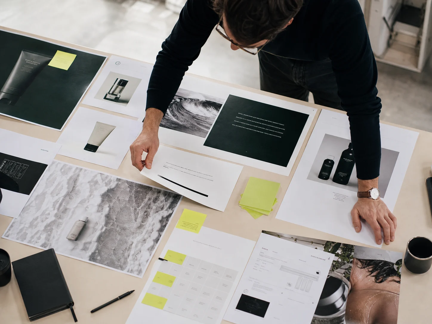 An art director arranging campaign concepts and printed proofs