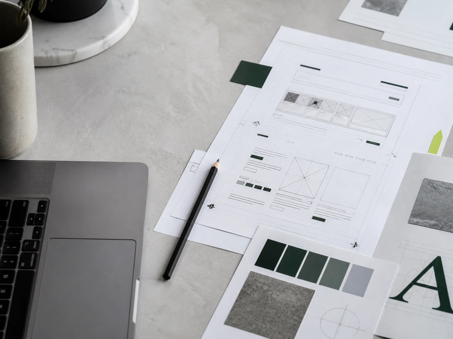 Website wireframes and brand materials on a design table